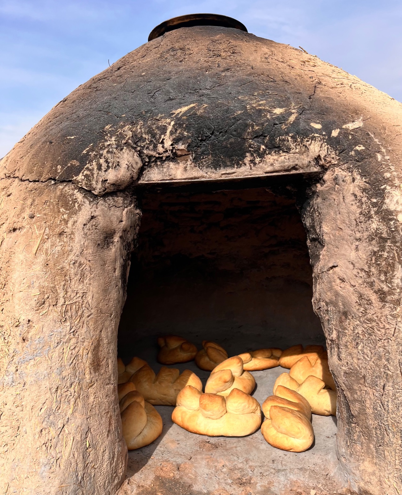 Fresh bread baking in an outdoor adobe horno