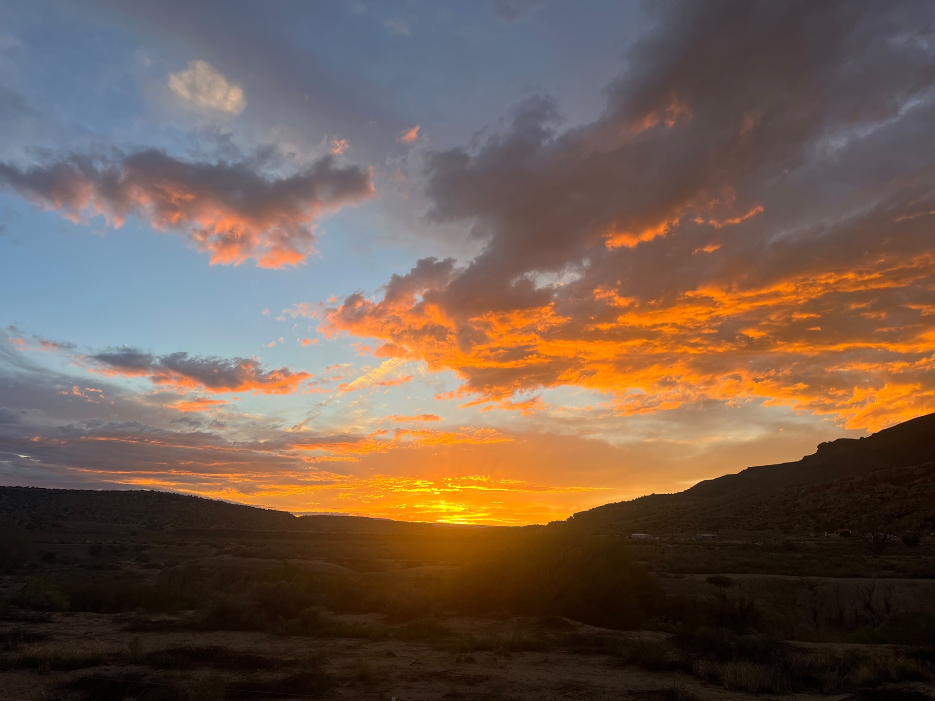 An orange and gold sunset over the mesas
